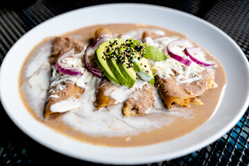 Enfrijoladas with avocado, onion and cheese