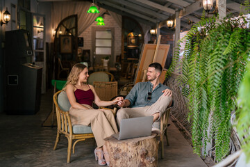 Obraz na płótnie Canvas Loving young couple looking at laptop at workplace. The concept of couples sharing one idea together.