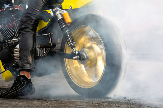 Motorbike burning tire rubber on road, Motorbike wheel drifting and white smoking on track, Motorcycle wheel on racing track with white smoke.