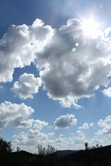 Obraz premium bright cumulus cloud and blue sky with mountain silhouette