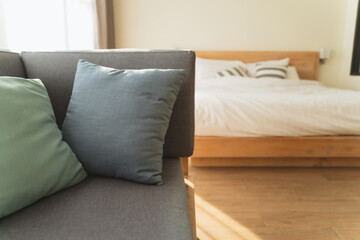 Close up of grey soft cushion sofa and pillows in minimal clean hotel bedroom or at home, house in morning holiday trip. Home interior design Travel and hotel or home for relax and rest idea concept.