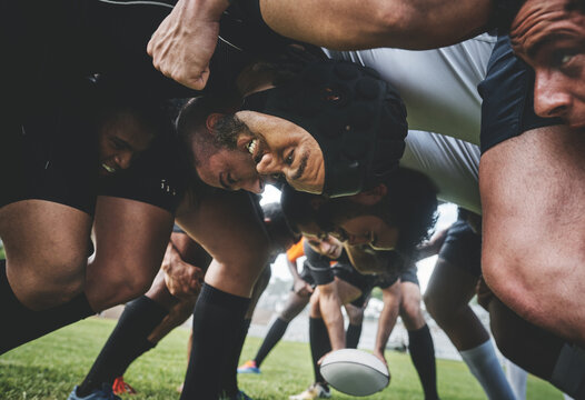 Sports, rugby and players in a scrum on a field during a game, workout or training in a stadium. Fitness, performance and group of athletes in position on an outdoor grass pitch for match or practice