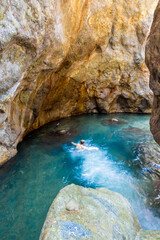 man swimming in a beautiful natural turquoise pool in a rocky cave in the province of Puntarenas in Costa Rica