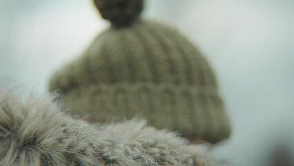 Close-up of woman wearing fur hooded coat and bobble hat - Powered by Adobe