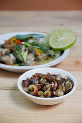 selective focus on white bowl serving sea snail or Laevistrombus canarium in Indonesian is called siput gonggong. soft focus
