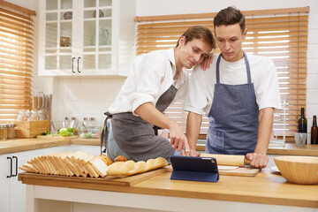 LGBT gay couple bake bakery together in the kitchen