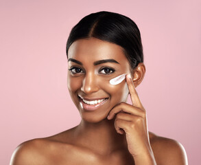 Happy, skincare and face of woman with cream in studio isolated on a pink background. Dermatology,...