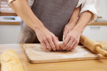 close up gay couple hands making a bread together in the kitchen