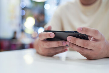 Man playing game on mobile phone. gamer boy playing video games holding Smartphone working mobile devices. cell telephone technology e-commerce concept