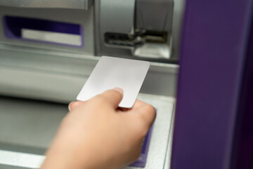 Close up of female hand using credit To withdrawing Money from atm Machine.