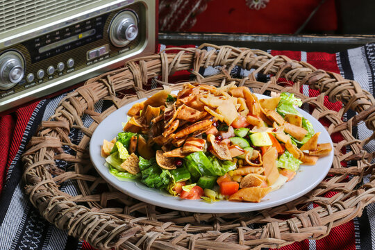 Fatoosh, fatoosh salad with crackers, cucumber, tomato, onion served in dish isolated on red mat top view on table arabic food