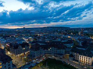 Fototapeta na wymiar Aerial view over City of Zürich with skyline and main police station the foreground on a cloudy spring evening. Movie shot May 6th, 2023, Zurich, Switzerland.