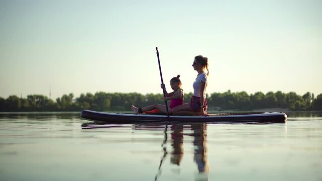 family using an inflatable board for rowing	