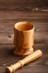 Fototapeta premium Close up of a wooden mortar and pestle on a wooden table. Copy space