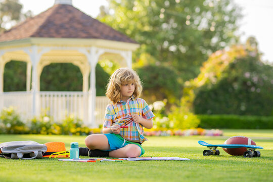 Kid boy create artist paints, summer vacation. School child drawing in summer park, painting art. Little painter draw pictures outdoor.
