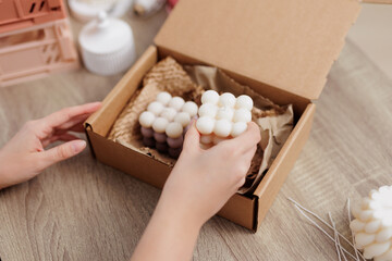 Fototapeta na wymiar Woman hands packing white candles in the box
