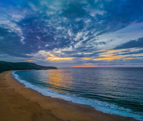 Fototapeta na wymiar Sunrise seascape with clouds and gentle surf