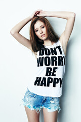 Portrait, young and a woman with a message on a shirt isolated on a white background in a studio. Fashion, stylish and a model with a tshirt and words of encouragement, empowerment and confidence