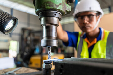 A worker operating lathe grinding machine - metalworking industry concept. Mechanical Engineering control lathe machine in factory. Selective focus of lathe machine.