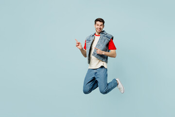 Full body fun young man he wear denim vest red t-shirt casual clothes jump high point indicate on...