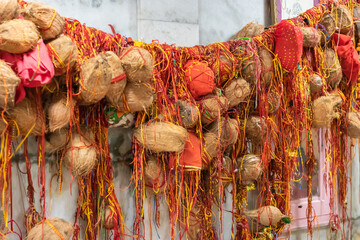 peeled coconut many tied with holy red threads at temple for god blessing