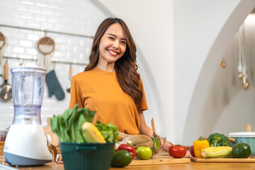 Portrait of beauty body slim healthy asian woman having fun cooking and preparing cooking vegan food healthy eat with fresh vegetable salad in kitchen at home.Diet concept.Fitness, wellness, healthy