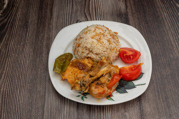 Fried chicken legs and rice in a white plate.