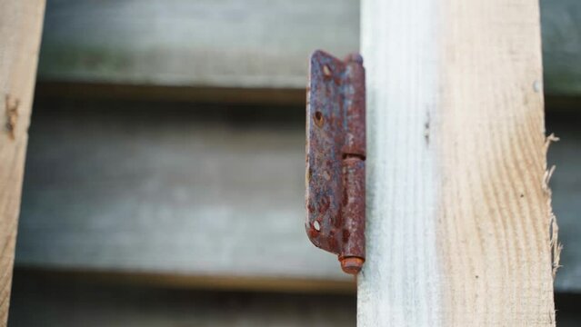 Rusty door hinge close-up. Dismantled door frame on the street, smooth camera movement