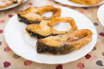 three pieces of fried carp on a white plate