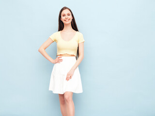 Image portrait of optimistic woman in yellow  t-shirt and white skirt. Carefree stylish model with long hair. Smiling female posing in studio. Isolated. Looks delightful and cute. Slim