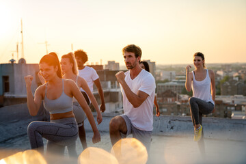 Healthy group of fit multiethnic friends exercising together outdoors. Sport people fun concept.