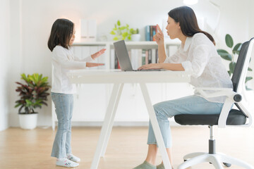 Mother trying to work at home office and daughter.
