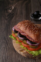 photo sausage and vegetable sandwich on a dark background