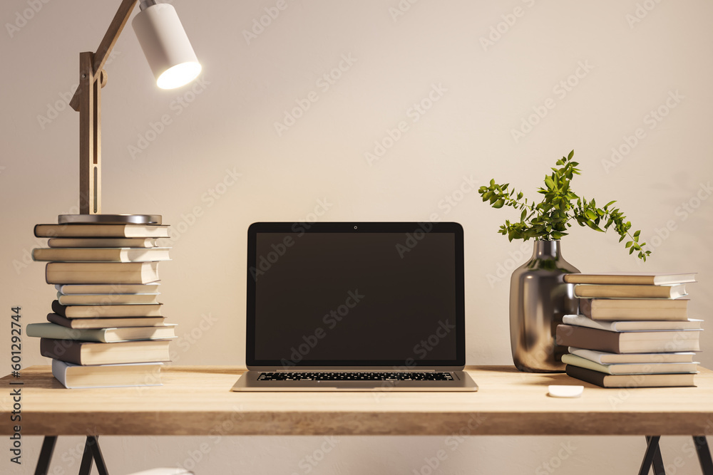 Poster front view of student wooden desk with blank screen laptop and a lot of books on beige wall backgrou