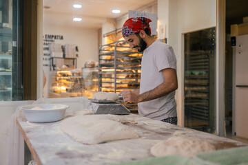 Arabic baker weighting dough with scale