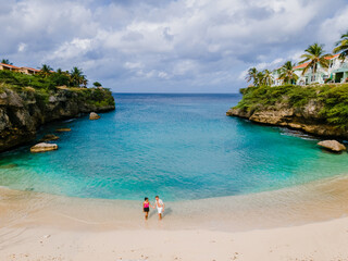 Fototapeta na wymiar A couple of men and women in swimshorts and bikinis at Playa Lagun Beach Cliff Curacao, 
