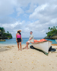 Obraz premium A couple of men and women in swimshorts and bikinis at Playa Lagun Beach Cliff Curacao, 