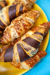 Chocolate croissants or croissant with nut crumbs on a plate. Breakfast on the table. Sweet baking dessert for coffee.