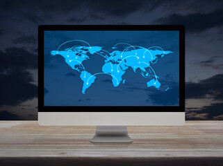 Connection line with global world map on computer monitor screen on wooden table over sunset sky, Technology communication online concept, Elements of this image furnished by NASA