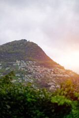 Lugano, Switzerland - 04 20 2023: A view of the city located on the alpine hills next to the lake and surrounded by mountains and forests