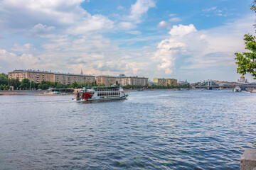 Naklejka premium Cruise ship sails on the Moscow river in Moscow city center, popular place for walking.