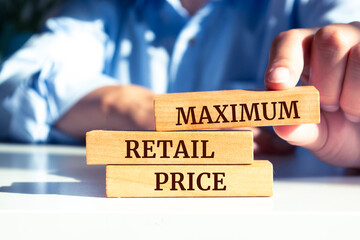 Close up on businessman holding a wooden block with "Maximum Retail Price" message