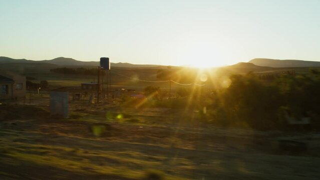 Driving past a old African township with sunset