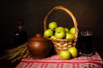 Apples in a basket, towel, spikelets of wheat, wine