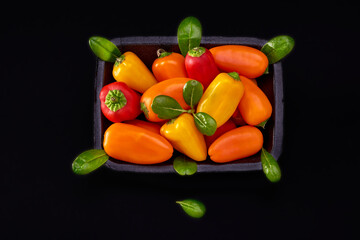 Bright sweet peppers on the black background