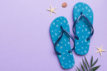 Flat lay composition with flip flops and seashell on colored background. Space for text top view