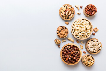 mixed nuts in wooden bowl. Mix of various nuts on colored background. pistachios, cashews, walnuts,...