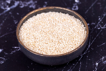 Sesame seeds. Organic White Sesame seeds (Sesamum indicum) on dark background. Close up