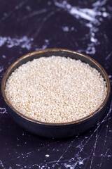 Sesame seeds. Organic White Sesame seeds (Sesamum indicum) on dark background