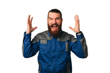 Nervous handy man wearing blue uniform screams and shows while gesturing. Studio shot over white...